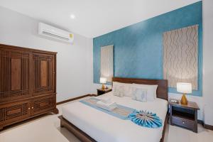 um quarto com uma cama e uma parede azul em MyVillage Lamai em Lamai