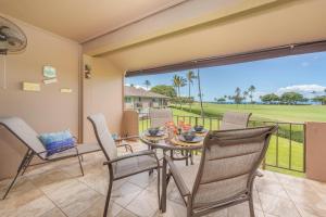 a dining room with a table and chairs and a balcony at Eldorado J222 in Kahana