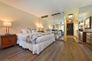 a bedroom with a large bed and a large mirror at Eldorado J209 in Kahana