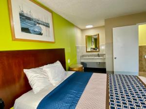 a bedroom with a bed and a bathroom with a sink at 4 Star Motel in Los Angeles