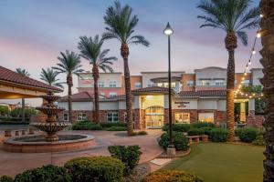 ośrodek wypoczynkowy z palmami i fontanną w obiekcie Residence Inn Phoenix Glendale Sports & Entertainment District w mieście Glendale