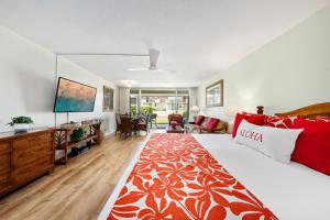 a bedroom with a large bed with red and white pillows at Eldorado J111 in Kahana