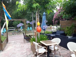 un patio avec des chaises, des tables et des parasols dans l'établissement Résidence Fleur des Pins - Gites & Chambres d'Hôtes, à Saint-Georges-dʼOléron