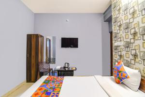 a bedroom with a bed and a wall with photographs at FabExpress Westin Palaza in kolkata