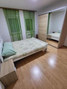 a bedroom with a large bed and a mirror at Stan u centru Prnjavor in Prnjavor