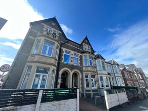 un edificio en una calle con un banco delante en Victoria House by Switchback Stays, en Cardiff