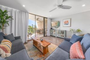 ein Wohnzimmer mit einer blauen Couch und einem Tisch in der Unterkunft Maui Sunset A404 in Kihei
