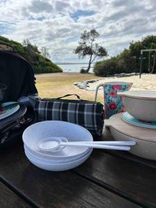 a wooden table with a bowl and a spoon on it at Sea Rest in Forster