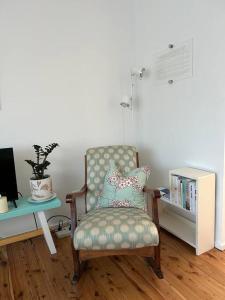 a living room with a chair and a book shelf at Sea Rest in Forster