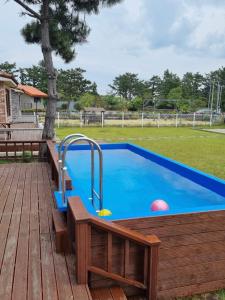 a lap pool with a wooden deck and a wooden at Jeju Sunshine Pension in Jeju
