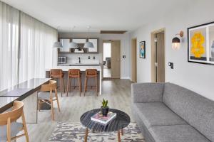 a living room and kitchen with a couch and a table at AC Hotel by Marriott Greenville in Greenville