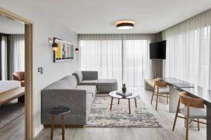 a living room with a couch and a table at AC Hotel by Marriott Greenville in Greenville