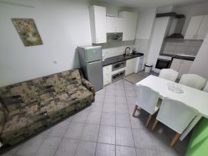 uma sala de estar com um sofá, uma mesa e uma cozinha em Stan u centru Prnjavor em Prnjavor