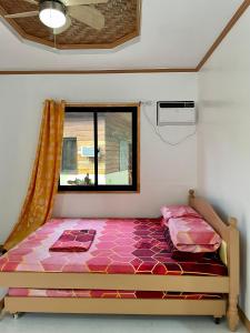 łóżko w pokoju z oknem w obiekcie Ana's Bungalow w mieście Siquijor