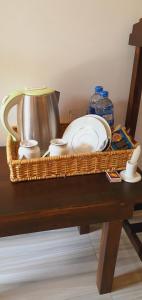 SMW Lodge Sigiriya في سيجيريا: سلة الخوص مع الأطباق وقدر الشاي على الطاولة
