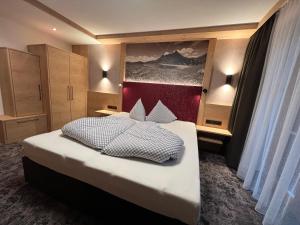 ein Schlafzimmer mit einem großen Bett mit einer roten Wand in der Unterkunft Jenneweinhof in Tux