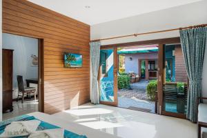 a bedroom with a bed and a view of a yard at MyVillage Lamai in Lamai
