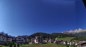 un villaggio con case e montagne sullo sfondo di Mansarda Accogliente Falcade Dolomiti a Falcade
