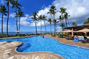 a swimming pool with palm trees and the ocean at Wailea Ekahi 32B in Wailea
