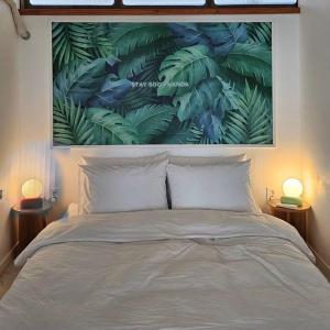 Schlafzimmer mit einem Bett mit Wandgemälde in der Unterkunft Exclusive House Hanok Stay 'Soo Hanok' in Suncheon