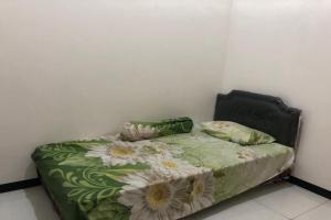 una camera da letto con un letto fiorito di OYO Life 2678 Manyar Guest House a Surabaya