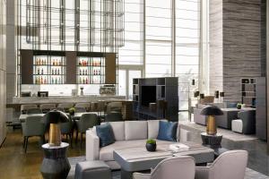 a lobby with a couch and chairs and a bar at Jiaxing Marriott Hotel in Jiaxing