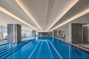 a large pool with blue water in a building at Jiaxing Marriott Hotel in Jiaxing