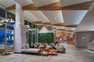 a lobby with couches and chairs in a building at The Westin Irving Convention Center at Las Colinas in Irving