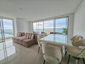 comedor con mesa de cristal y sillas en Living Cartagena vista al mar y cuidad amurallada, en Cartagena de Indias