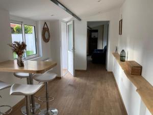 uma cozinha e sala de estar com uma mesa e bancos em Micro maison Lyon 8/ Parking / Terrain de pétanque em Bron