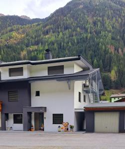 um edifício preto e branco com uma montanha ao fundo em Mountain JoLe em Neustift im Stubaital