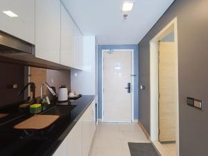 a kitchen with a sink and a door to a bathroom at Straits Residence Melaka Private Suites in Melaka