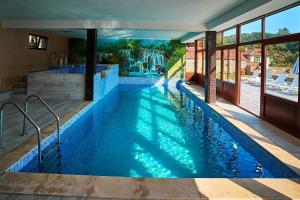a swimming pool with blue water in a house at Симида 2 in Debnevo