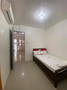 1 dormitorio con 1 cama y puerta que da a un pasillo en WJV INN MARIBAG0 en Maribago