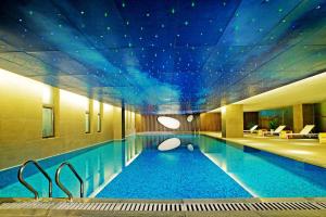 a large swimming pool with a ceiling with stars at Aloft Zhengzhou Shangjie in Zhengzhou