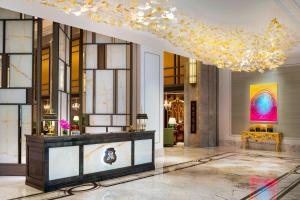 a lobby with a large chandelier and a table at The St. Regis Shanghai Jingan in Shanghai