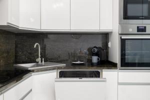 Kuchyňa alebo kuchynka v ubytovaní Kapitański Mostek Apartments Kołobrzeg by Noclegi Renters