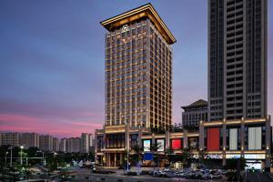 a tall building with a clock on top of it at Sheraton Yunfu Xinxing Hotel in Yunfu