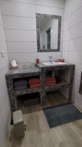 a bathroom with a stone sink and a mirror at U Maestrale in Canale-di-Verde