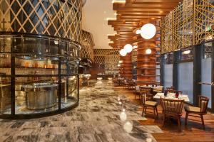 a restaurant with tables and chairs and a lobby at The Westin Qingdao West Coast in Huangdao