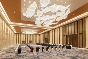 黄岛青岛西海岸威斯汀酒店的一间会议室,里面摆放着一排椅子和吊灯 更多37张照片