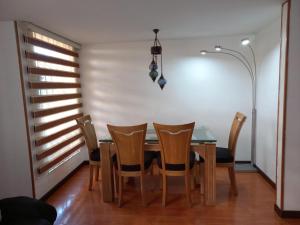 una sala da pranzo con tavolo e sedie di Casa amoblada en Colina Campestre a Bogotá