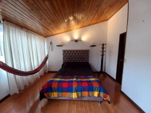 um quarto com uma cama e um tecto de madeira em Casa amoblada en Colina Campestre em Bogotá
