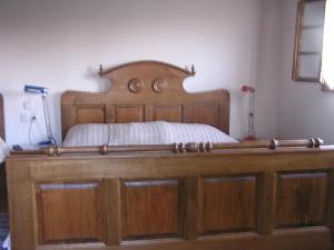 a bed with a wooden headboard in a room at Tradicije Cigoc in Čigoč