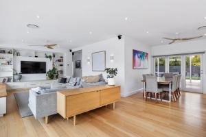 a living room with a couch and a table at Granville House - Hamptons style in Lindisfarne
