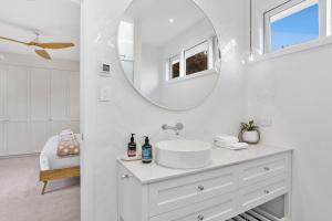 a white bathroom with a sink and a mirror at Granville House - Hamptons style in Lindisfarne +12 photos