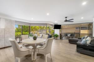 a dining room and living room with a table and chairs at Surfside Court - Hosted by Burleigh Letting in Gold Coast