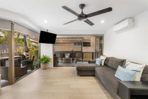 a living room with a couch and a ceiling fan at Surfside Court - Hosted by Burleigh Letting in Gold Coast