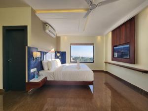 a bedroom with a large bed and a window at Portola Hotel By Parkside in Dharamshala