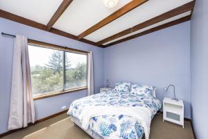 吉爾德頓的住宿－Seascape - Outstanding Views Pet Friendly Free WIFI Netflix，蓝色的卧室设有床和窗户